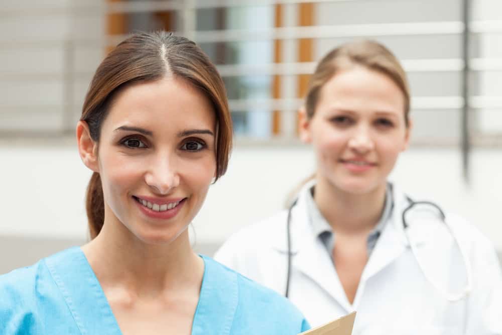 Smiling nurse and doctor standing in a hospital reception
